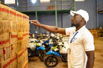 Ein HI-Mitarbeiter in Mali checkt die Lieferbestände von Handicap International in einem Lager