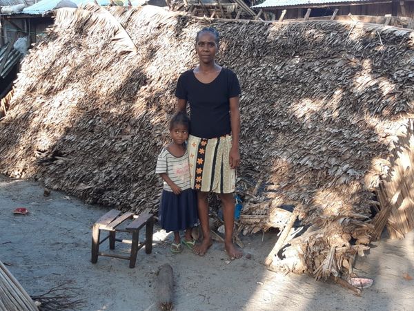 Eine Frau und ein Kind stehen von ihrer Hütte in Madagaskar