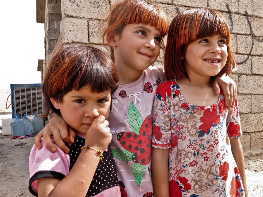 Saadis drei Töchter stehen Arm in Arm vor ihrer Unterkunft. 