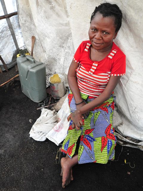 Jeanette lehnt an einem Zelt in einem Flüchtlingscamp im Kongo und blickt starr in die Kamera.