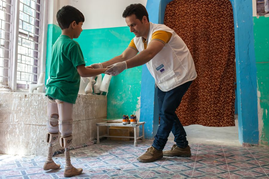 Zu sehen ist Fayaz mit einem Therapeuten von Handicap International. Er schult Fayaz für den Umgang mit seinen Prothesen.