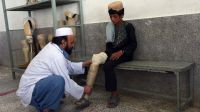 Ein Therapeuth hilft einem jungen mit seiner Prothese