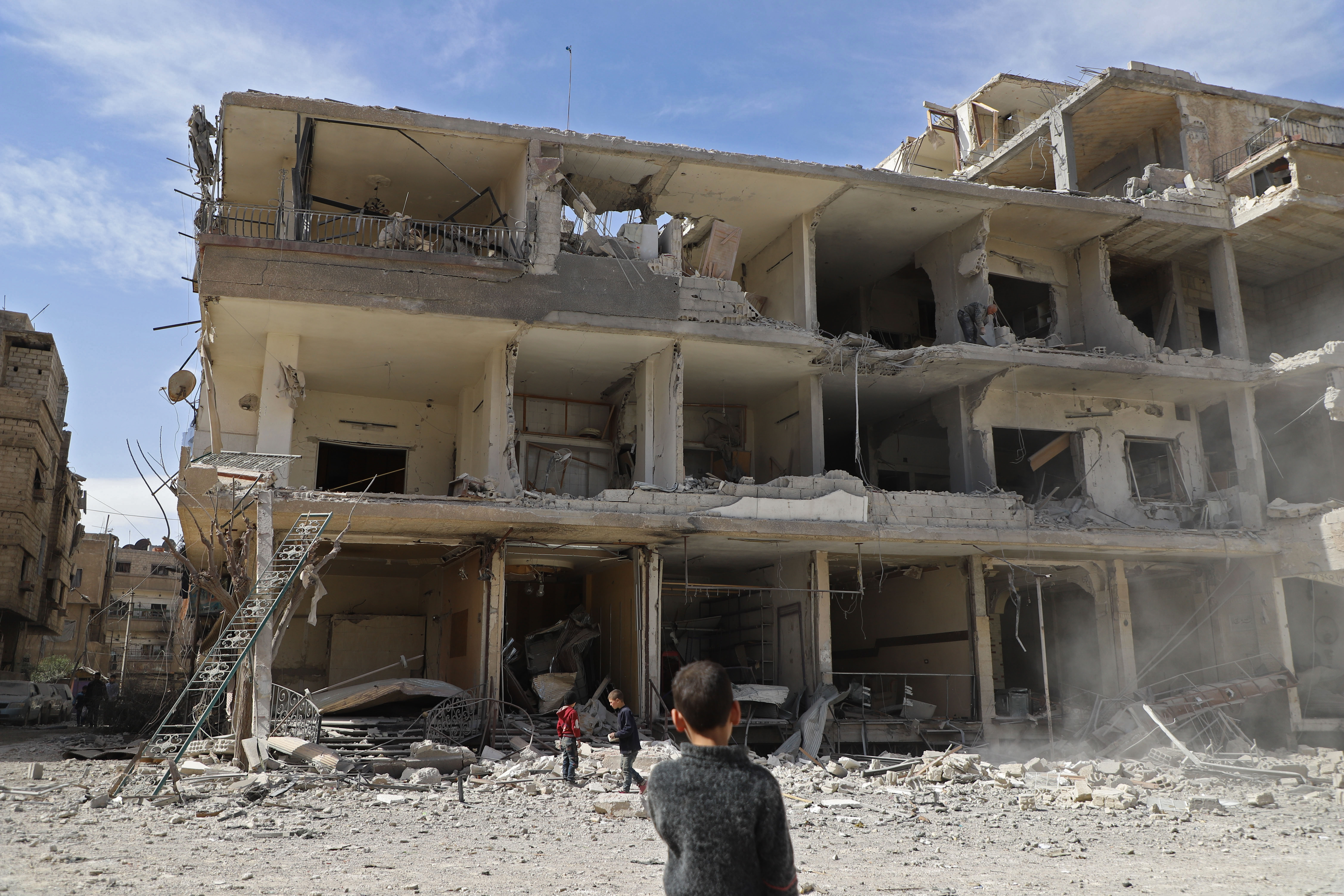 Syrische Kinder erkunden ein zerstörtes Gebäude in Kafar Batna in der Enklave Ost-Ghouta 