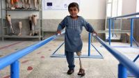Sanaullah, ein Junge in hellblauen Kleidern ist in dem HI Reha-Zentrum zu sehen. Unter seinem langen Oberteil ist die Beinprothese deutlich zu sehen. Hier ist er bei Laufübungen abgebildet