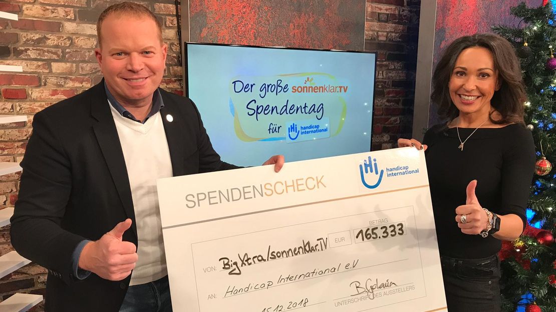 Der HI Marketing-Leiter Thomas Schiffelmann nimmt den sonnenklar.TV Spenden-Scheck entgegen.