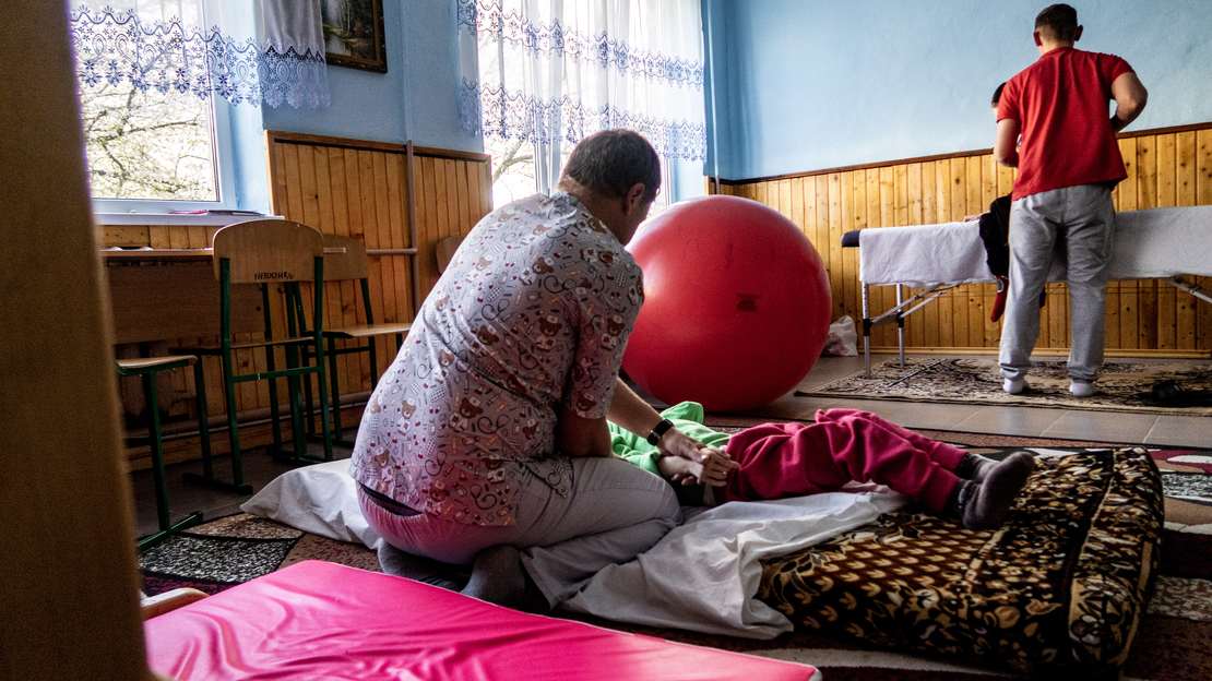 Zu sehen sind Physiotherapie-Spezialisten bei der Arbeit mit Kindern.