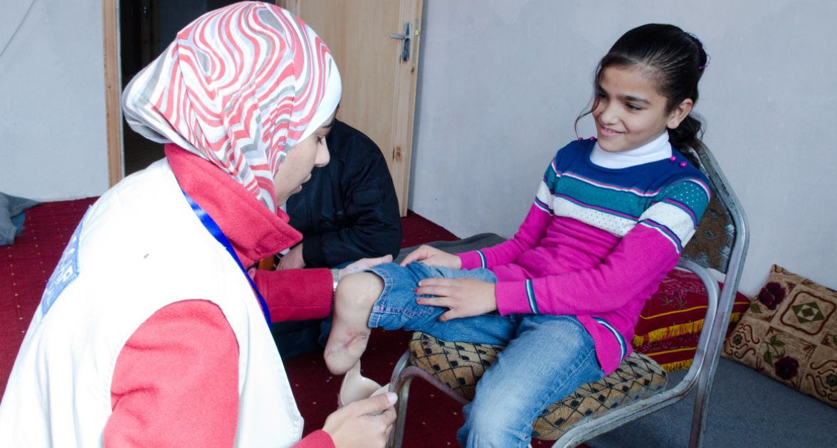 Physiotherapeutin Saud Shehadeh hilft Maryam beim Ansetzen ihrer Prothese.
