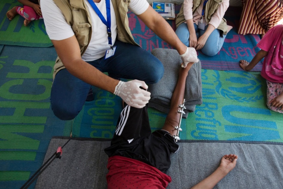 Mohammad, Physiotherapeut von HI, mit Abdallah, 13 Jahre, aus West-Mossul. Bei der Explosion einer Rakete erlitt er einen Bruch. Das Bein wird von einem externen Fixateur gehalten.