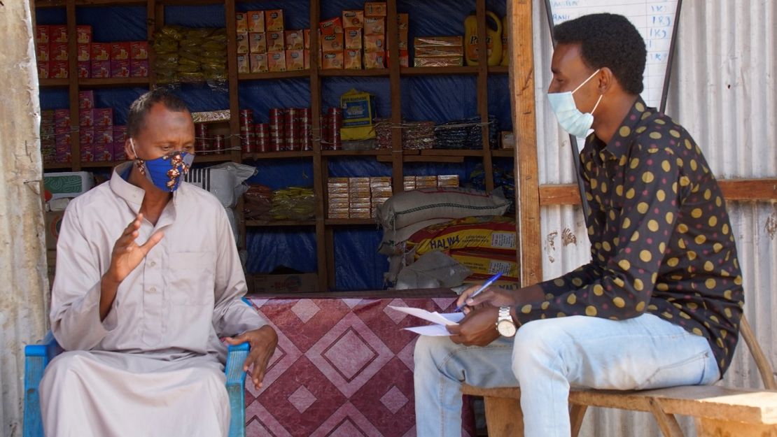 Ahmed mit Maske im Gespräch mit seinem Physiotherapeuten von Handicap International.