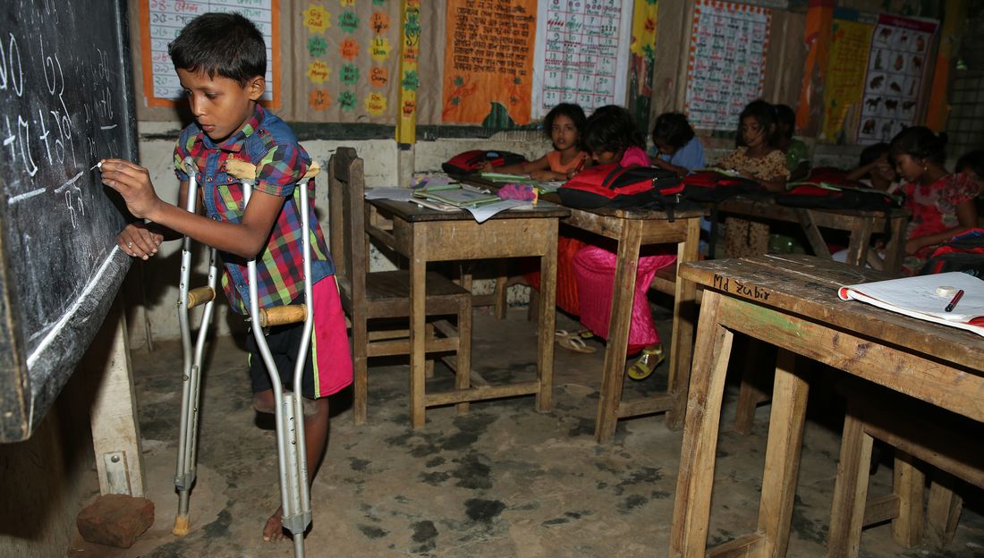 Saiful aus Myanmar ist auf Krücken angewiesen. Er steht vor seiner Klasse an der Tafel.