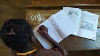 A little girl working on her schoolwork in a school supported by HI. Inclusive education project in the Atsinanana region, Madagascar. ©L.Bluman / HI; }}