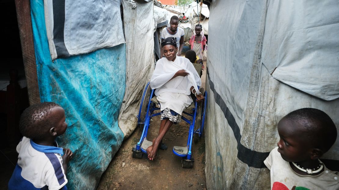 Lina, die im Rollstuhl sitzt, braucht im Flüchtlingscamp Unterstützung, um durch die engen, unebenen Gänge zu kommen.