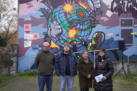 Eine Gruppe Menschen stehen vor dem Dusiburger Graffiti.