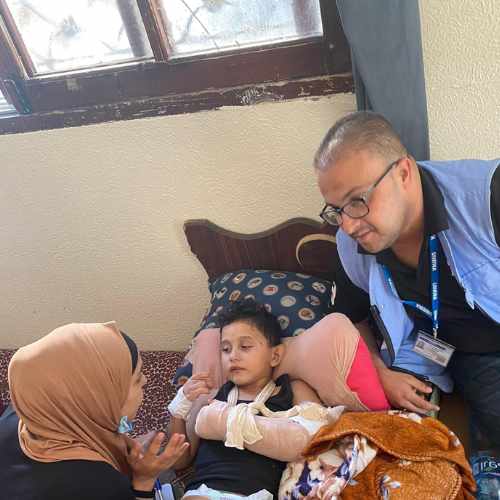 Ein kleiner verletzter Junge liegt in einem Bett in Gaza. Er hat einen eingebundenen Arm und viele Kratzer im Gesicht.