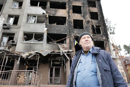 Ein Mann vor einem von Bombenangriffen zerstörten Haus in Irpin