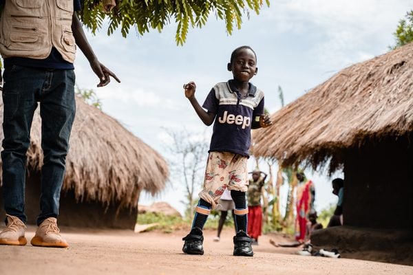 Kennedy aus Uganda bei der Physiotherapie mit einem HI-Mitarbeiter