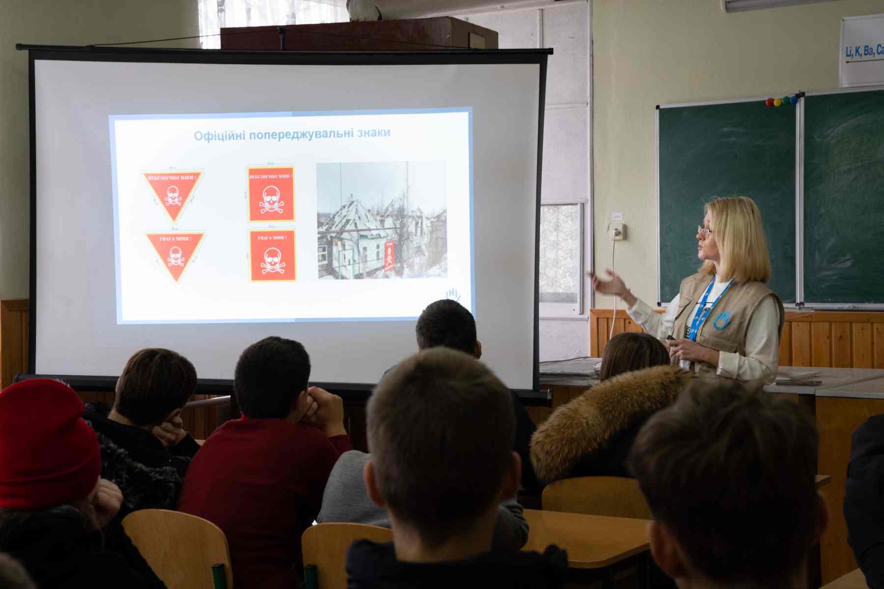 Frau vor Projektor klärt über Gefahr von Blindgängern auf