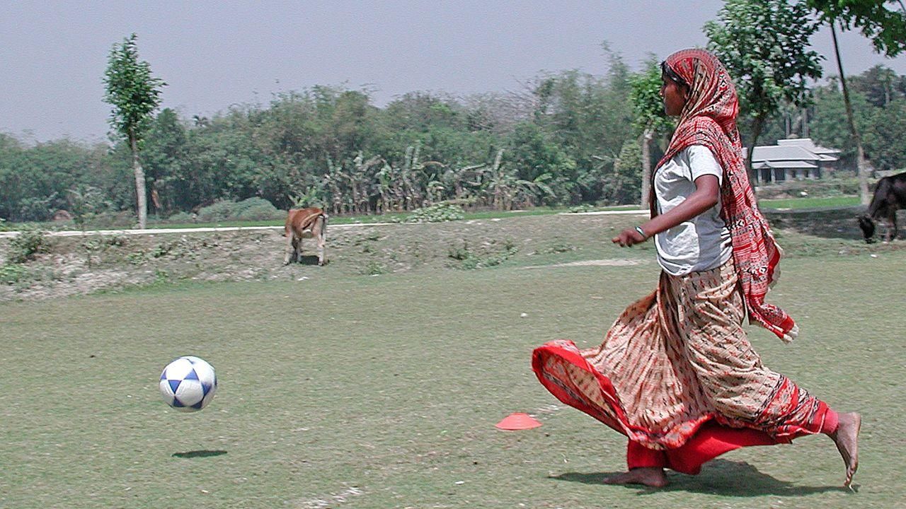 Sportprojekt in Bangladesch. Ein Mädchen spielt Fußball.