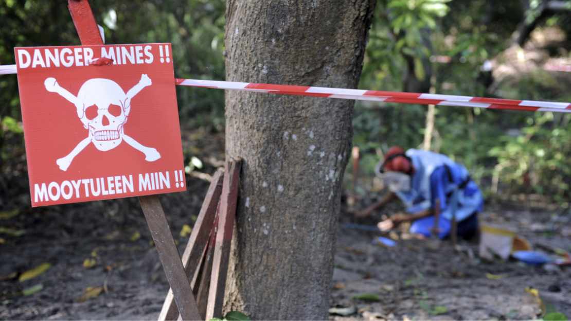 Im Vordergrund ist ein rotes Schild mit einem Totenkopf und der Aufschrift 
