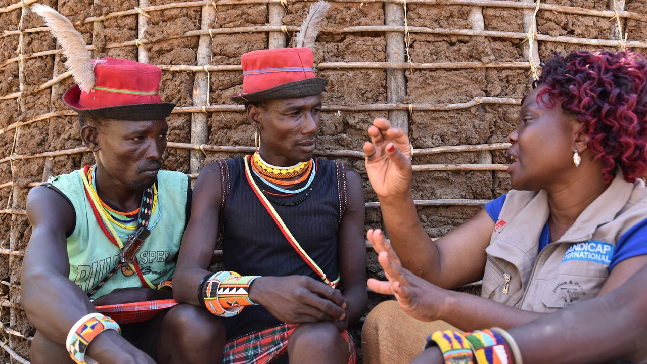 Gorrety Ajwang von Handicap International im Gespräch mit zwei Kriegern der Pokot.