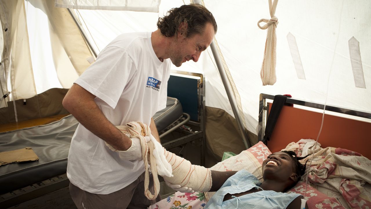 Olivier Champagne bei einer lachenden Patientin in einem Nothilfezelt in Haiti.