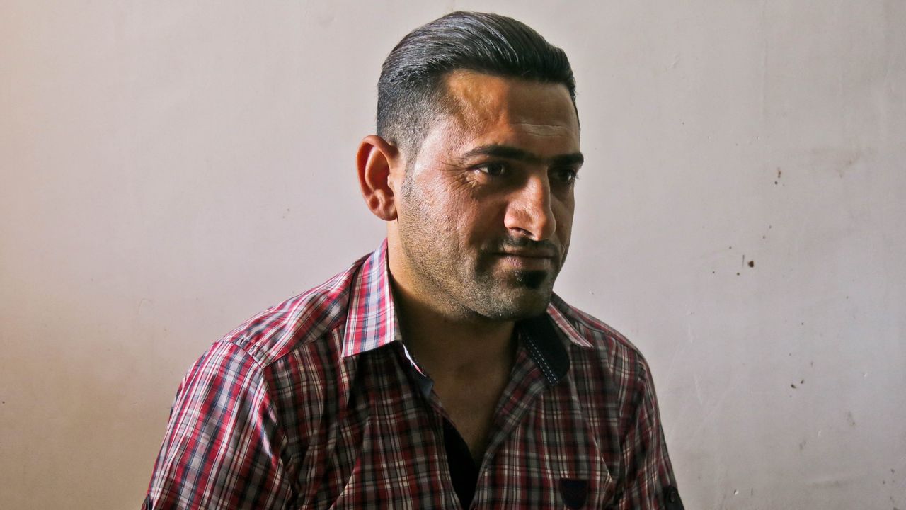 Abdelillah befindet sich in einem Raum und schaut an der Kamera vorbei