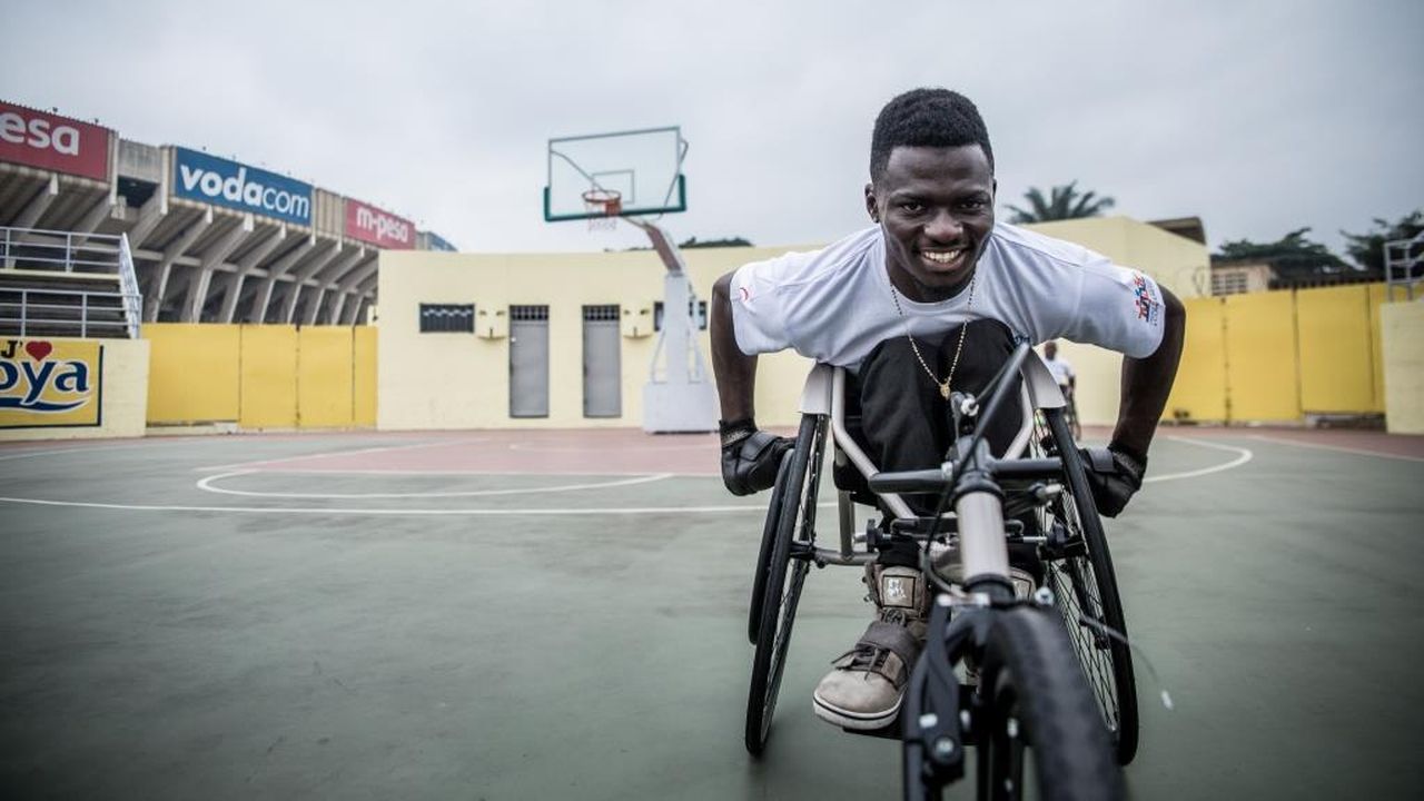 John Mwegani in seinem neuen Rollstuhl auf einem Sportplatz