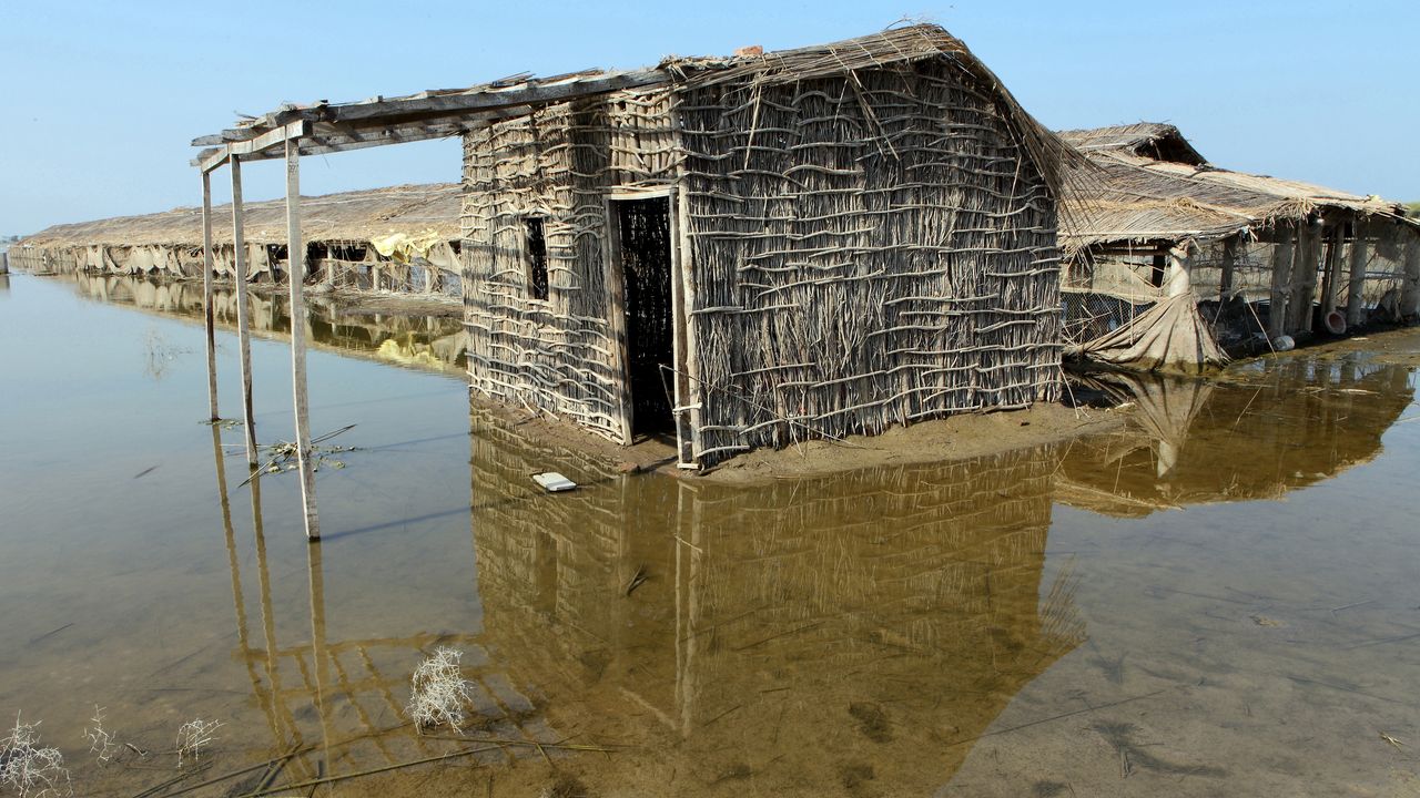 Ein Haus aus Lehmziegeln steht mitten in dem überschwemmten Gebiet.