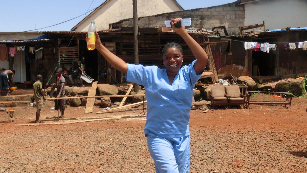 Eine unsere Mitarbeiterinnen läuft freudig durch ein Dorf in Sierra Leone.