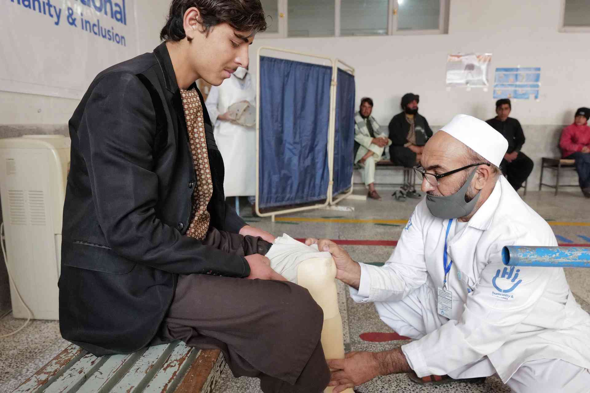 Ein junger Mann bei der Reha zusammen mit einem Mitarbeiter von Handicap International