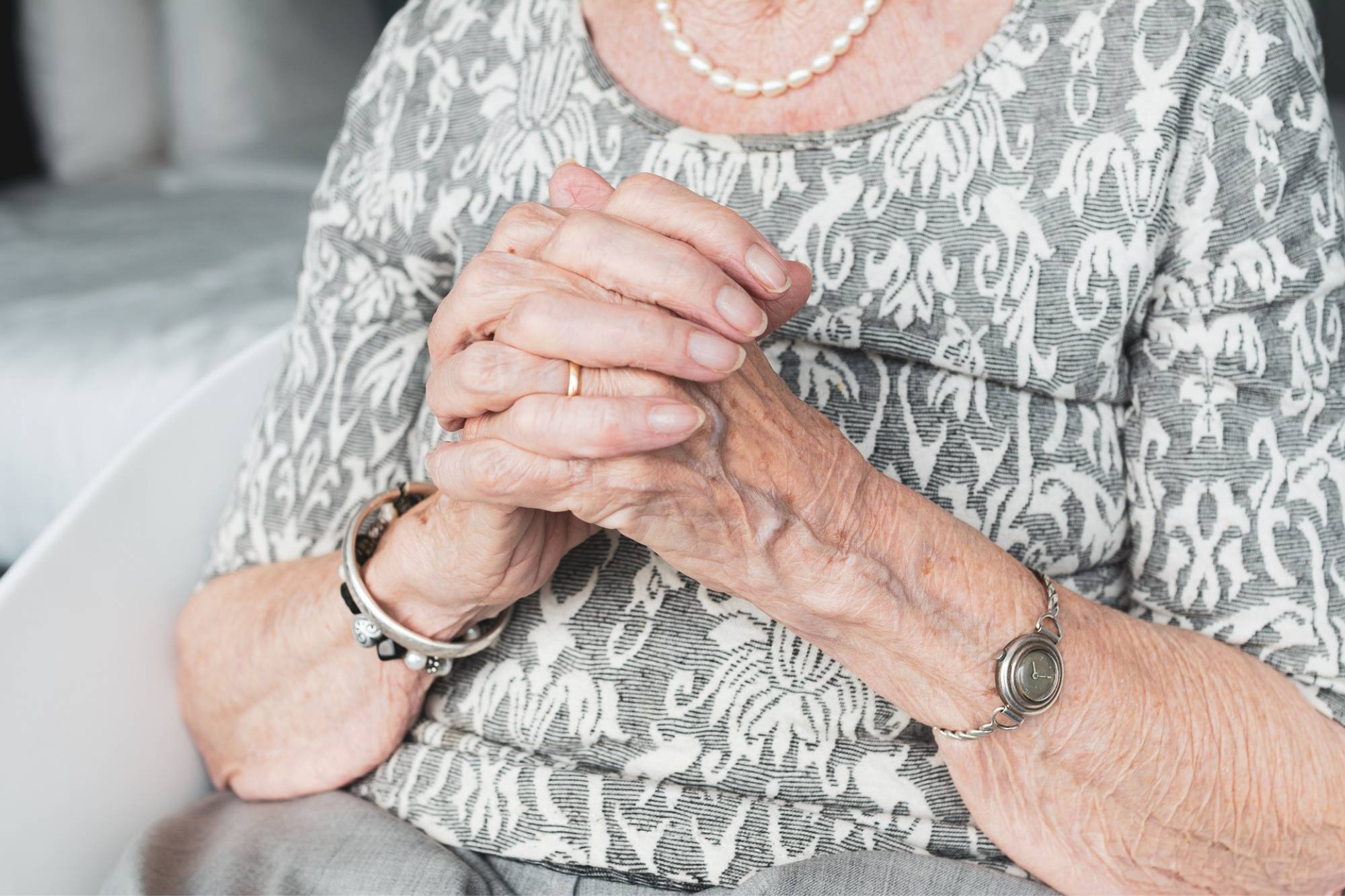 Nahaufnahme von gefalteten Händen einer alten Frau