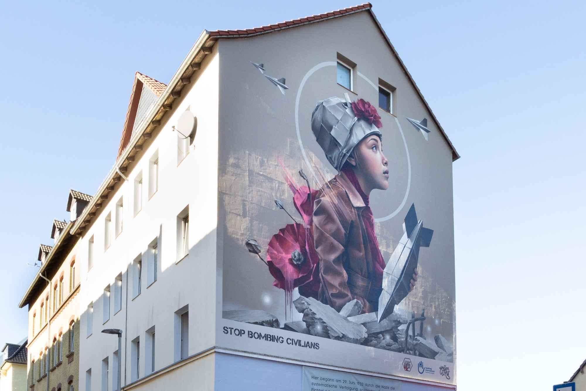 Das Graffiti ist zeigt ein junges Mädchen zwischen den Trümmern