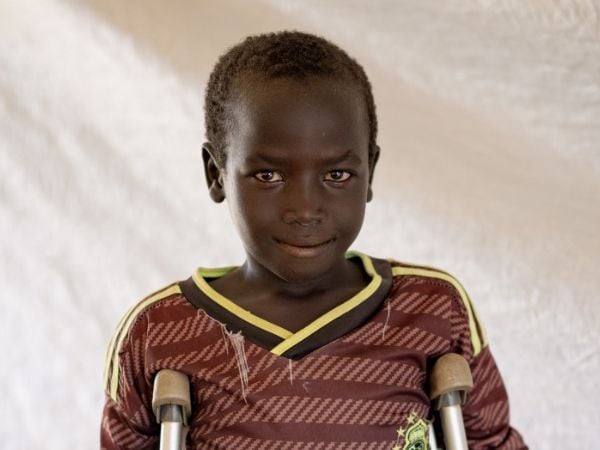 9-jähriger Junge aus dem Sudan mit Krücken. Ihm fehlt ein Bein.