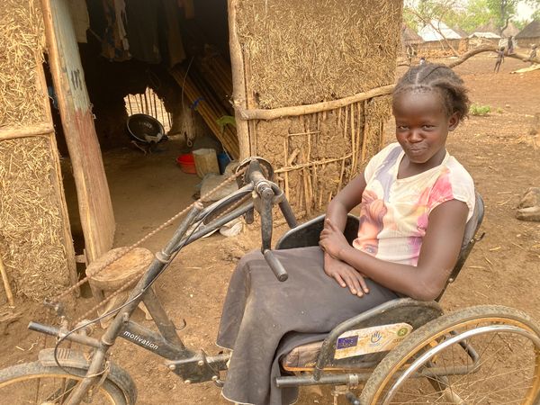 Nyadouth aus dem Südsudan floh nach Äthiopien. Sie sitzt in einer Art Dreirad, um sich fortzubewegen. © Till Mayer / HI
