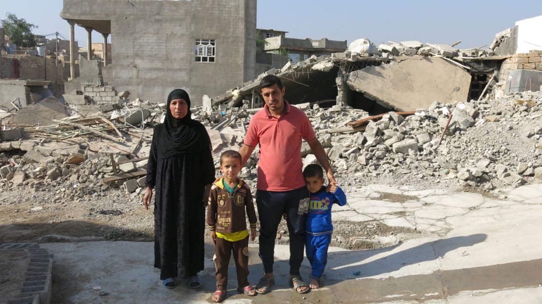 Familie vor den Trümmern ihres Hauses im Irak