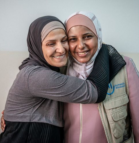 Wafa aus Syrien mit ihrer Physiotherapeutin von Handicap International. Sie strahlt.