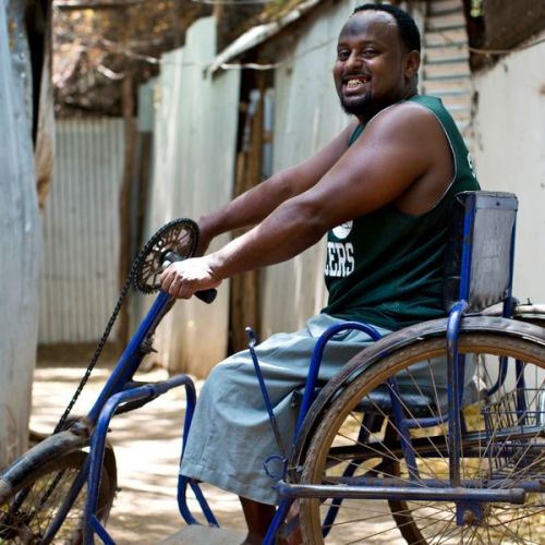 Ein lächelnder Mann sitzt auf einem Dreirad für Erwachsene