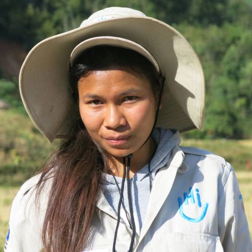 Eine junge Frau aus Laos. sie trägt eine HI-Uniform und einen breiten Sonnenhut