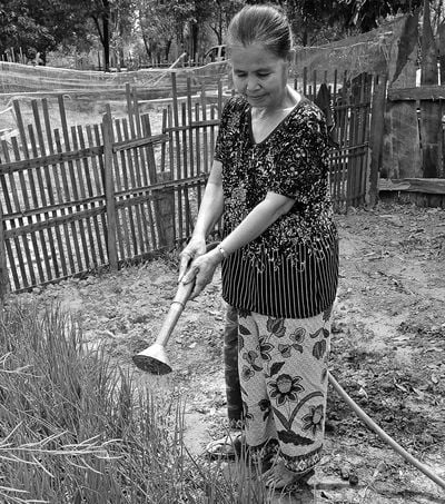 Phet aus Laos verlor im Krieg mit 16 ihr Bein. Auf dem Bild arbeitet sie im Garten.