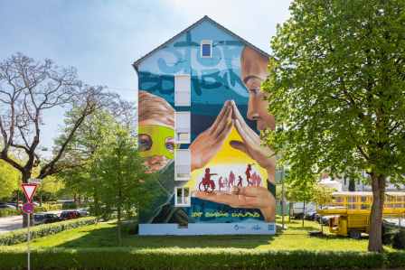 Das haushohe Mural auf der Fassade eines Wohnhauses im Augsburger Antonsviertel.