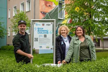 Eine Gruppe Menschen stehen vor dem Augsburger Graffiti und enthüllen eine Tafel.