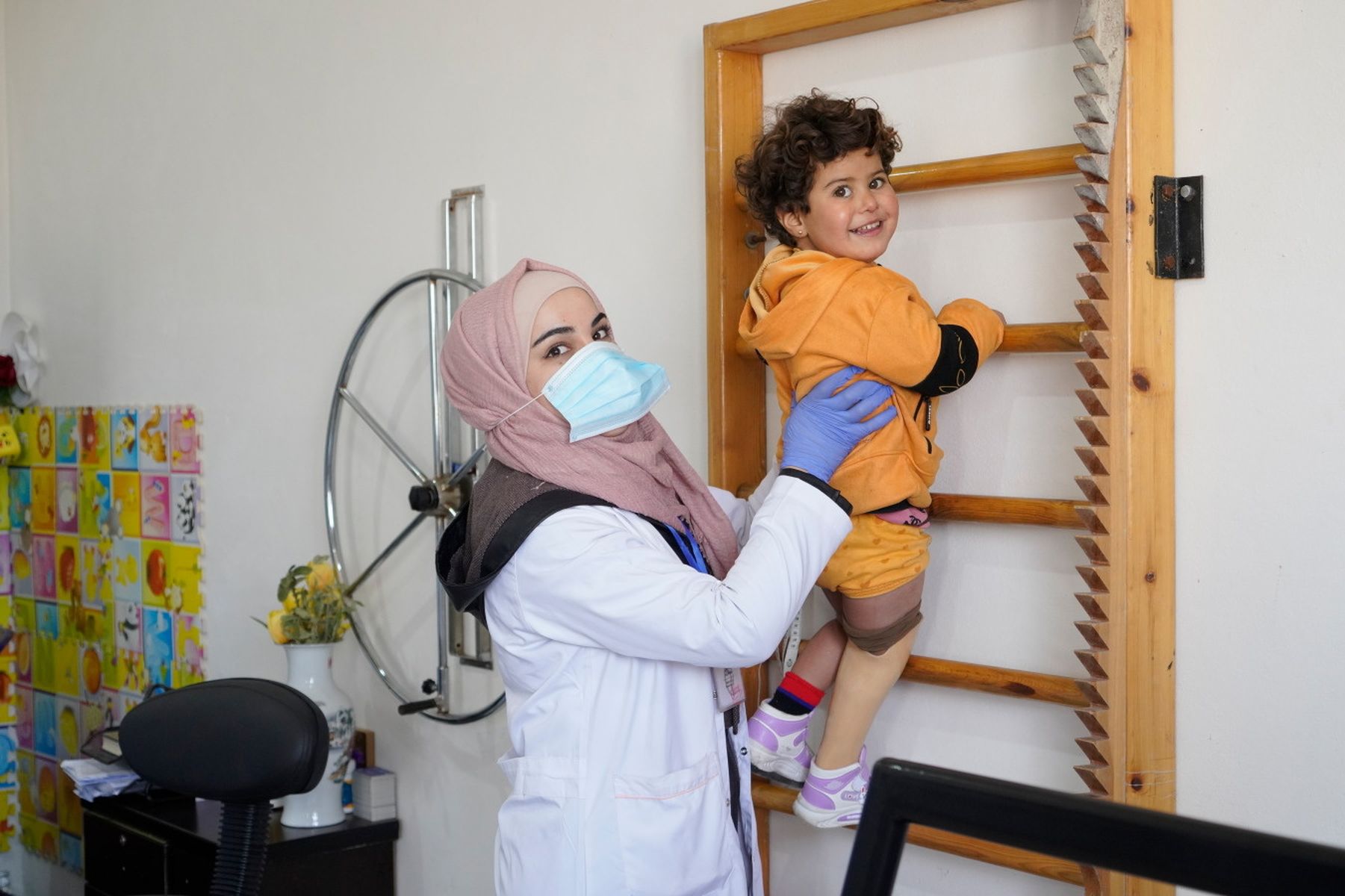 Die 4-jährige Noor hat beim Erdbeben ein Bein verloren. Mithilfe ihrer Physiotherapeutin klettert sie eine Sprossenwand hoch.