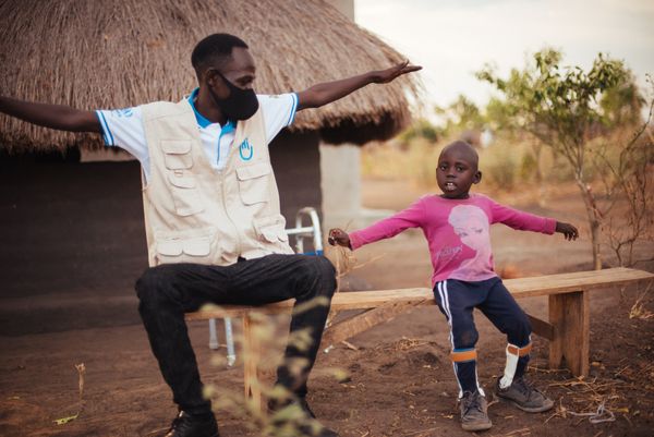 Kennedy aus Uganda bei der Physiotherapie mit einem HI-Mitarbeiter