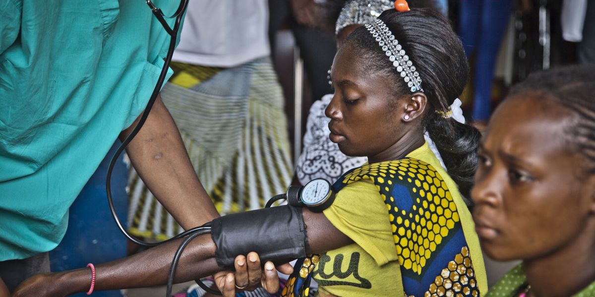 Bei einer Frau aus Senegal wird Blutdruck gemessen