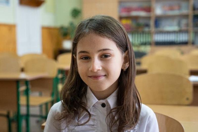 Ein lächelndes Mädchen im Klassenzimmer