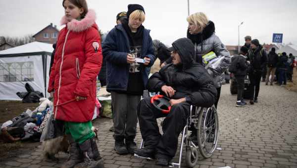 Ukrainische Geflüchtete, darunter ein junger Mann im Rollstuhl.