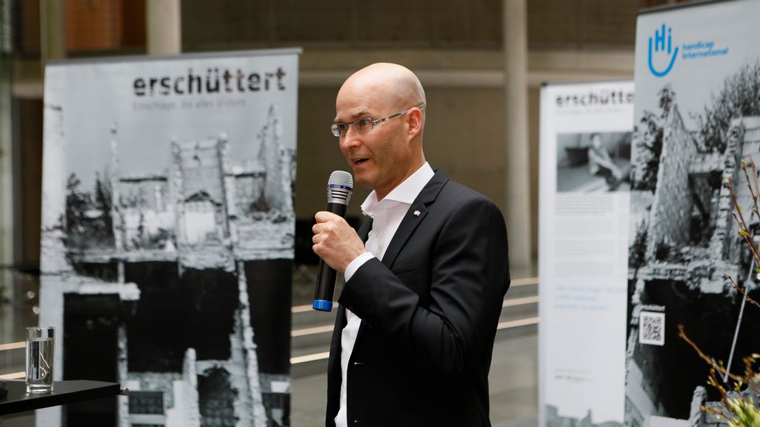 Fotojournalist Till Mayer bei seiner Eröffnungsrede der Ausstellung 'erschüttert' im Deutschen Bundestag.