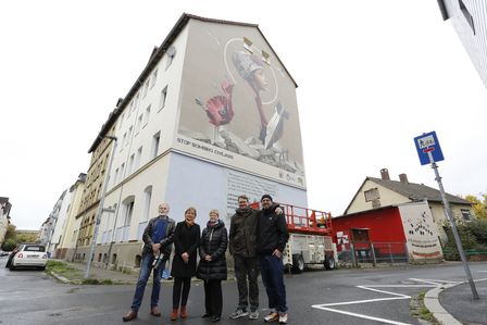 Eine Gruppe Menschen stehen vor dem Braunschweiger Graffiti.
