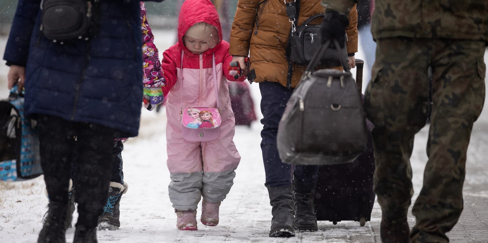 Flüchtlinge im Winter, eine kleines Mädchen geht an der Hand seiner Eltern
