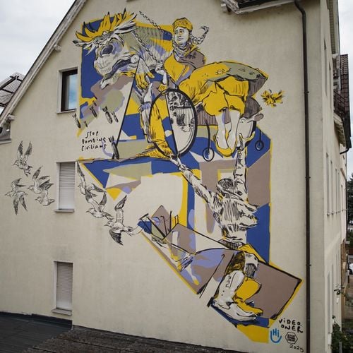 Das Graffiti ist angelehnt an Picassos Guernica und zeigt unter anderem ein Mädchen, das in einem Rollstuhl an Ketten schaukelt.